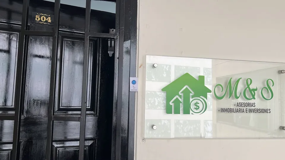 Puerta negra de la oficina 504 junto al aviso de vidrio de M&S, Asesorías, Inmobiliaria e Inversiones